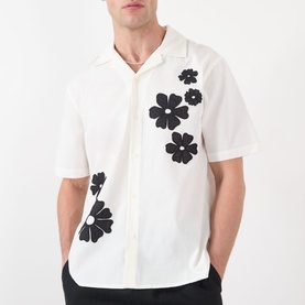 Model wearing Wax London Didcot Floral Shirt in ecru and black with bold floral embroideries, camp collar and short sleeves