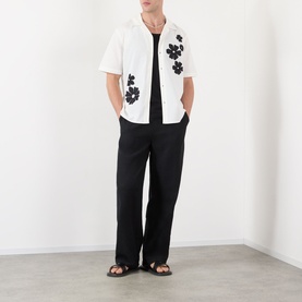 Model wearing Wax London Didcot Floral Shirt in ecru with black floral embroideries, styled with black trousers and sandals.