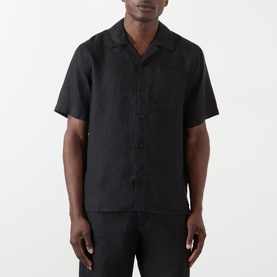 Model wearing Wax London Didcot Linen Bowling Shirt in black, with notched collar, short sleeves and chest pocket, styled with matching black