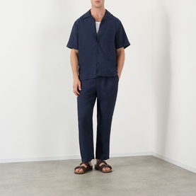 Model wearing Wax London navy linen casual shirt with matching navy trousers and brown leather sandals.