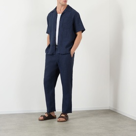 Model wearing Wax London navy linen casual shirt with matching navy trousers and brown sandals.
