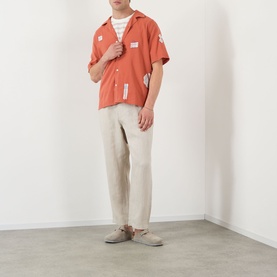 Model wearing Wax London Didcot Scribble Casual Shirt in terracotta with ecru appliqu&eacute;, styled with stone linen trousers and suede loafers.