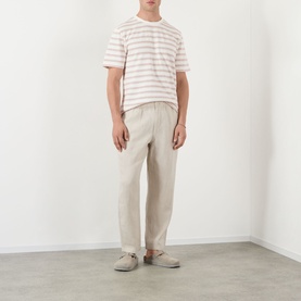 Model wearing Wax London Kurt Linen Relaxed Fit Trousers in beige, styled with a striped t-shirt and slip-on shoes.