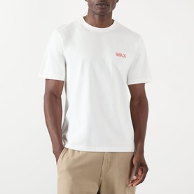 Model wearing Wax London Dean Logo Embroidery T-Shirt in ecru with rust logo, crew neck, styled with stone chinos.