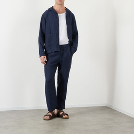 Model wearing Wax London Navy Linen Casual Trousers, styled with matching navy linen jacket, white tee and brown sandals.