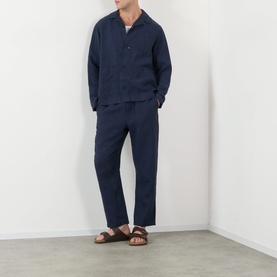 Model wearing Wax London Navy Linen Casual Trousers, styled with matching navy linen shirt and brown leather sandals.