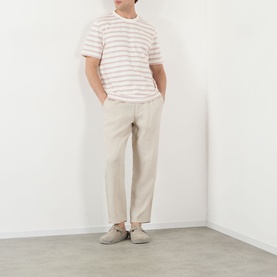 Model wearing Wax London Dean Stitched Striped T-Shirt in ecru/rust, styled with beige trousers and grey slip-on shoes.
