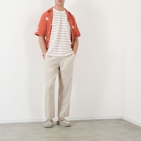 Model wearing Wax London Dean Stitched Striped T-Shirt in ecru/rust, styled with a rust shirt, stone linen trousers and grey suede shoes.
