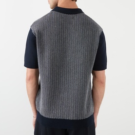 Model wearing Wax London Turin Knitted Polo Shirt in navy, rear view showing textured knit panel, contrast ribbed trims and short sleeves.