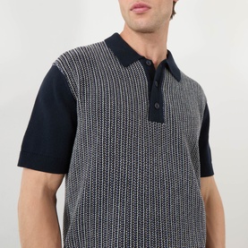 Model wearing Wax London Turin Knitted Polo Shirt in navy, featuring geometric knit pattern, polo collar and buttoned placket. Short sleeves with