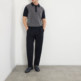 Model wearing Wax London Turin Knitted Polo Shirt in navy with black trousers and dark loafers.