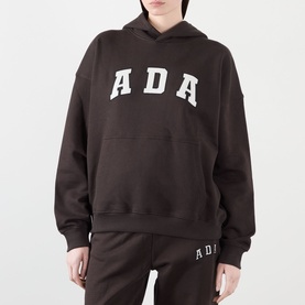 Model wearing Adanola ADA Logo Oversized Hoodie in Coffee Bean, styled with matching ADA joggers. Fixed hood, kangaroo pocket, bold logo lettering.