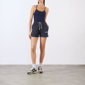 Model wearing Adanola Midnight Blue shorts with Marshmellow White drawstring, styled with matching navy bodysuit and white ankle socks with trainers.