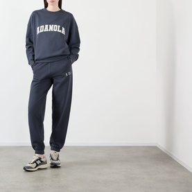 Model wearing Adanola Varsity Logo Oversized Sweatshirt in Midnight Blue with matching joggers and chunky trainers.