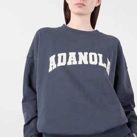 Model wearing Adanola Varsity Logo Oversized Sweatshirt in Midnight Blue, with white varsity-style logo across the chest and crew neckline.
