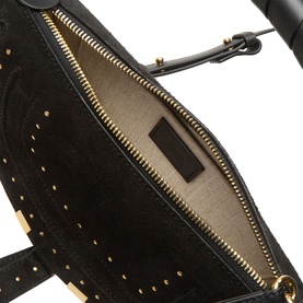Chlo&eacute; black calfskin crossbody bag interior view showing gold-tone zip, linen-cotton lining, and studded detailing along the edge