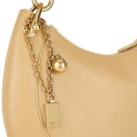 Chlo&eacute; Dusty Beige leather shoulder bag with gold-tone chain strap, ball charm, and rectangular logo tag detail.