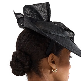 Model wearing Phase Eight black sinamay fascinator hat with bow detail, styled on upswept hair with gold hoop earrings visible.