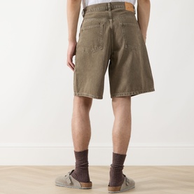 Model wearing Les Deux Washed Denim Shorts in light brown denim wash, back view, styled with grey socks and suede trainers