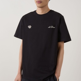 Model wearing Les Deux black cotton T-shirt with small chest embroidery logo detail, crew neck and short sleeves.