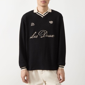 Model wearing Les Deux Waffle Football Top in black with cream V-neck collar, stripe trims, script logo embroidery, and long sleeves