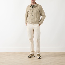 Model wearing Levis The Trucker Denim Jacket in Yellow Sand with cream trousers and chunky trainers