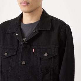 Model wearing Levi's casual denim jacket in black, featuring classic trucker collar, chest pockets and branded red tab detail.