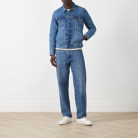 Model wearing Levi's washed blue denim casual jacket with matching blue jeans and white trainers.