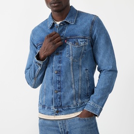 Model wearing Levi's casual denim jacket in washed blue, featuring chest pockets and button front, styled with a white crew-neck tee.