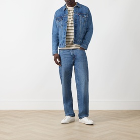 Model wearing Levi's washed blue denim casual jacket with striped T-shirt and matching blue jeans, styled with white trainers.