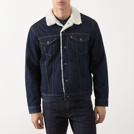 Model wearing Levis Type III Sherpa Trucker Jacket in dark indigo with cream sherpa collar lining, styled with matching dark denim jeans.