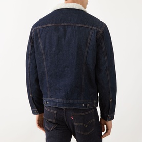 Model wearing Levis Type III Sherpa Trucker Jacket in Give It A Rinse Sherpa, dark indigo denim with sherpa collar, back view, styled with dark jeans.