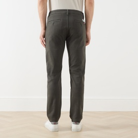 Model wearing Levis XX Mid-Rise Chino in Komodo Shady green, rear view showing logo patch, belt loops and straight leg fit, styled with white
