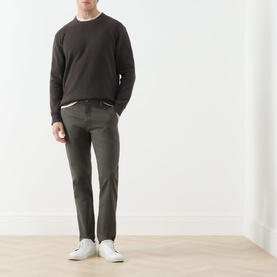 Model wearing Levis XX Chino in Komodo Shady green, styled with a dark sweatshirt and white trainers. Mid-rise fit with belt loops.
