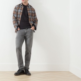 Model wearing Levis Mineral Black Crew Neck T-shirt, styled with brown plaid overshirt and grey jeans.