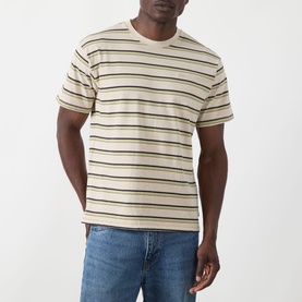 Model wearing Levis Stripe Logo T-Shirt in Martin Stripe Winter Pear, styled with blue denim jeans. Crew neck, short sleeves, horizontal stripe