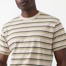 Model wearing Levis Stripe Logo T-Shirt in Martin Stripe Winter Pear, a cream tee with navy and green horizontal stripes and crew neck.