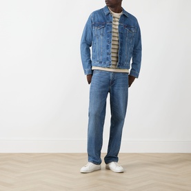 Model wearing Levis Stripe Logo T-Shirt in Martin Stripe Winter Pear, styled with blue denim jacket and jeans, white trainers.