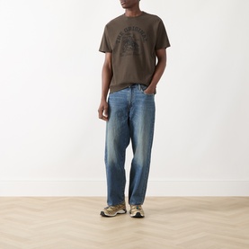 Model wearing Levi's Crew Neck T in Original 2H Brand Coffee Jersey, styled with mid-wash straight-leg jeans and retro trainers.
