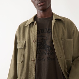 Model wearing Levi's Original 2H Brand Coffee Jersey Crew Neck T-shirt, styled under an open khaki overshirt.