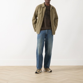 Model wearing Levis Crew Neck T in Original 2H Brand Coffee Jersey, styled with olive overshirt and mid-wash wide-leg jeans.