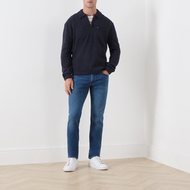 Model wearing Levis Boulder Half-Zip Polo Sweater in navy, styled with mid-blue straight-leg jeans and white trainers.