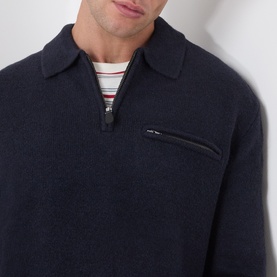 Model wearing Levi's Boulder Half-Zip Polo Sweater in navy, showing polo collar, half-zip and chest zip pocket, styled over a striped top.