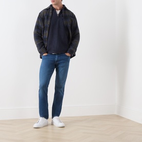 Model wearing Levis Boulder Half-Zip Polo Sweater in Navy HTR Novelty Stitch, styled with a dark checked jacket and blue jeans.