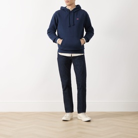 Model wearing Levi's navy blazer french terry hoodie, styled with white shirt, dark trousers and white trainers.