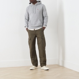 Model wearing Levi's Medium Vintage Htr Grey cotton hoodie with olive cargo trousers and white low-top trainers.