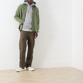 Model wearing Levis Medium Vintage HTR Grey hoodie, styled with olive shirt jacket, dark brown cargo trousers and cream trainers.