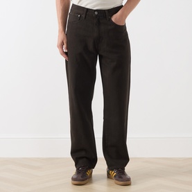 Model wearing Levis 568&trade; Loose Straight Leg Jeans in Mudslides OD, dark brown loose straight fit with five-pocket styling, styled with yellow trainers