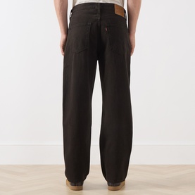 Model wearing Levi's 568&trade; Loose Straight Leg Jeans in Mudslides OD, shown from rear, with dark wash finish and logo patch.