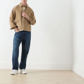 Model wearing Levi's 3049 Loose Jeans in Hard Rain dark blue wash, styled with a tan jacket and white trainers.